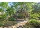 Secluded backyard with a stone path, deck, and mature landscaping surrounding the property at 1270 Taylor Oaks Dr, Roswell, GA 30076