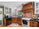 Kitchen with granite countertops, a gas cooktop, custom wood range hood, and hardwood floors at 1270 Taylor Oaks Dr, Roswell, GA 30076