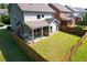 Aerial view of a fenced backyard with a covered patio and ample green space at 2600 Arnold Palmer Way, Duluth, GA 30096