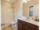 Well-lit bathroom featuring a shower-tub combo, dark wood cabinets, and a single sink at 2600 Arnold Palmer Way, Duluth, GA 30096