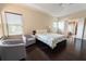 Bright bedroom featuring hardwood floors, a ceiling fan and two chairs by the windows at 2600 Arnold Palmer Way, Duluth, GA 30096