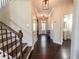 Inviting foyer with hardwood floors, staircase, and views of a half bath and front door at 2600 Arnold Palmer Way, Duluth, GA 30096
