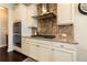 This gourmet kitchen features a gas cooktop, stainless steel appliances and a tile backsplash at 2600 Arnold Palmer Way, Duluth, GA 30096