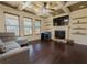 Comfortable living room featuring a tray ceiling, fireplace, and large windows at 2600 Arnold Palmer Way, Duluth, GA 30096