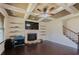 Open-concept living room showcasing tray ceilings, a fireplace, and hardwood floors at 2600 Arnold Palmer Way, Duluth, GA 30096