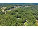 Wide aerial view of a home surrounded by lush green trees with residential area in the far distance at 5455 Malone Ct, Powder Springs, GA 30127