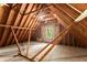 Unfinished attic space with exposed beams and a window at 5455 Malone Ct, Powder Springs, GA 30127