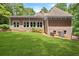 Backyard featuring a spacious, well-maintained lawn and tan colored house with large windows providing natural light at 5455 Malone Ct, Powder Springs, GA 30127