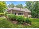 Landscaped backyard featuring a well-maintained lawn, lush hydrangeas, and large windows on a tan colored house at 5455 Malone Ct, Powder Springs, GA 30127