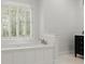 Bathroom with a soaking tub with shuttered windows and a dark vanity at 5455 Malone Ct, Powder Springs, GA 30127
