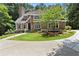 Charming home featuring manicured lawn, stone accents, brown stucco, and elegant white trimmed windows at 5455 Malone Ct, Powder Springs, GA 30127