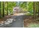 Traditional two story home with brown stucco and stone exterior with a long driveway at 5455 Malone Ct, Powder Springs, GA 30127