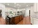 Bright kitchen with white cabinets, stainless steel appliances, granite countertops, and large island with bar stool seating at 5455 Malone Ct, Powder Springs, GA 30127