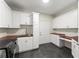 A spacious laundry room featuring white cabinets, wood countertops, and modern appliances at 5455 Malone Ct, Powder Springs, GA 30127