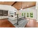 Bright living room with wood ceiling beams, fireplace, custom built-ins, and large windows overlooking the backyard at 5455 Malone Ct, Powder Springs, GA 30127