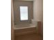 Clean bathroom with a window above a garden tub for natural light and relaxation at 5671 Radford Loop, Fairburn, GA 30213