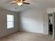 Bedroom featuring neutral carpet, walls, ceiling fan, and bathroom access at 5671 Radford Loop, Fairburn, GA 30213