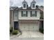 Charming two-story townhouse featuring a two-car garage and dormer windows at 5671 Radford Loop, Fairburn, GA 30213