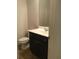 Powder room with vanity, sink, faucet, mirror, and toilet at 5671 Radford Loop, Fairburn, GA 30213