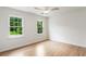 Spacious bedroom with hardwood floors, ceiling fan, and natural light from the windows at 2015 Clipper Straits, Snellville, GA 30078