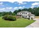 Spacious two-story home boasts a long driveway, white painted brick, front porch, and mature landscaping at 2015 Clipper Straits, Snellville, GA 30078