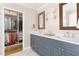 Bathroom with blue double sink vanity adjacent to closet with lots of storage at 2617 Warwick Ne Cir, Atlanta, GA 30345