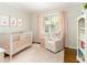 Bedroom with chair, crib, light pink decor, and lots of natural light at 2617 Warwick Ne Cir, Atlanta, GA 30345