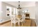 Dining room with a farmhouse-style table, modern chandelier, and view of the living room at 2617 Warwick Ne Cir, Atlanta, GA 30345