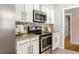 Kitchen with stainless steel oven, granite countertops, tile backsplash and white cabinets at 2617 Warwick Ne Cir, Atlanta, GA 30345