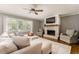 Cozy living room with brick fireplace, ceiling fan, and large windows for natural light at 2617 Warwick Ne Cir, Atlanta, GA 30345