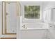 Bathroom featuring a glass shower, garden tub, and bright window with wooded view at 1575 Wynridge Pointe, Alpharetta, GA 30005