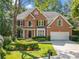 Attractive brick home with lush landscaping, a well-kept lawn, and a two-car garage at 1575 Wynridge Pointe, Alpharetta, GA 30005