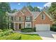 Beautiful brick home featuring manicured landscaping, healthy green grass, and a two-car garage at 1575 Wynridge Pointe, Alpharetta, GA 30005