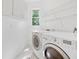 Functional laundry room with washer, dryer, and built-in shelving at 1575 Wynridge Pointe, Alpharetta, GA 30005
