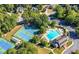 Community aerial view featuring a pool and tennis courts amid lush greenery, ideal for active living at 5355 Highland Pine Ln, Mableton, GA 30126