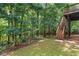 A lush green backyard with wooded area and a staircase leading to the deck at 5355 Highland Pine Ln, Mableton, GA 30126