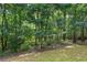 A serene backyard with dense trees and lush green grass at 5355 Highland Pine Ln, Mableton, GA 30126