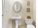 Classic powder room features a pedestal sink, toilet, decorative mirror, and artwork at 5355 Highland Pine Ln, Mableton, GA 30126