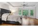 Light-filled primary bedroom features a ceiling fan, hardwood floors, and natural light at 5355 Highland Pine Ln, Mableton, GA 30126