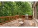 Wooden deck with grill, wooden furniture, and a view of the green backyard at 5355 Highland Pine Ln, Mableton, GA 30126