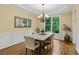Traditional dining room with hardwood floors, classic wainscoting, a chandelier, and a view to the trees at 5355 Highland Pine Ln, Mableton, GA 30126