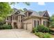 Charming two-story brick home with a well-manicured lawn, a three car garage and an arched entryway at 5355 Highland Pine Ln, Mableton, GA 30126