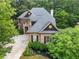 A beautiful exterior view of a two-story brick home with a well manicured yard surrounded by mature trees at 5355 Highland Pine Ln, Mableton, GA 30126