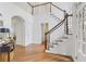 Bright foyer featuring hardwood floors, a staircase with white railings, and an open doorway to a living space at 5355 Highland Pine Ln, Mableton, GA 30126