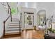 Bright, airy foyer with staircase, hardwood floors, high ceilings, and a view through the glass front door at 5355 Highland Pine Ln, Mableton, GA 30126