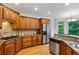Well-lit kitchen with warm wood cabinetry, stainless steel appliances, and stylish backsplash at 5355 Highland Pine Ln, Mableton, GA 30126