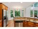 Open-concept kitchen with wood cabinets, breakfast bar, and adjacent dining area at 5355 Highland Pine Ln, Mableton, GA 30126