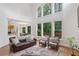 Living room with soaring ceilings, large windows with wooded views, and hardwood floors at 5355 Highland Pine Ln, Mableton, GA 30126