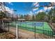 Community tennis courts surrounded by a secure fence and mature trees, perfect for recreational play at 5355 Highland Pine Ln, Mableton, GA 30126