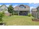 Large backyard with a covered patio, green lawn, and neatly trimmed shrubs at 876 Samples Nw Ln, Atlanta, GA 30318